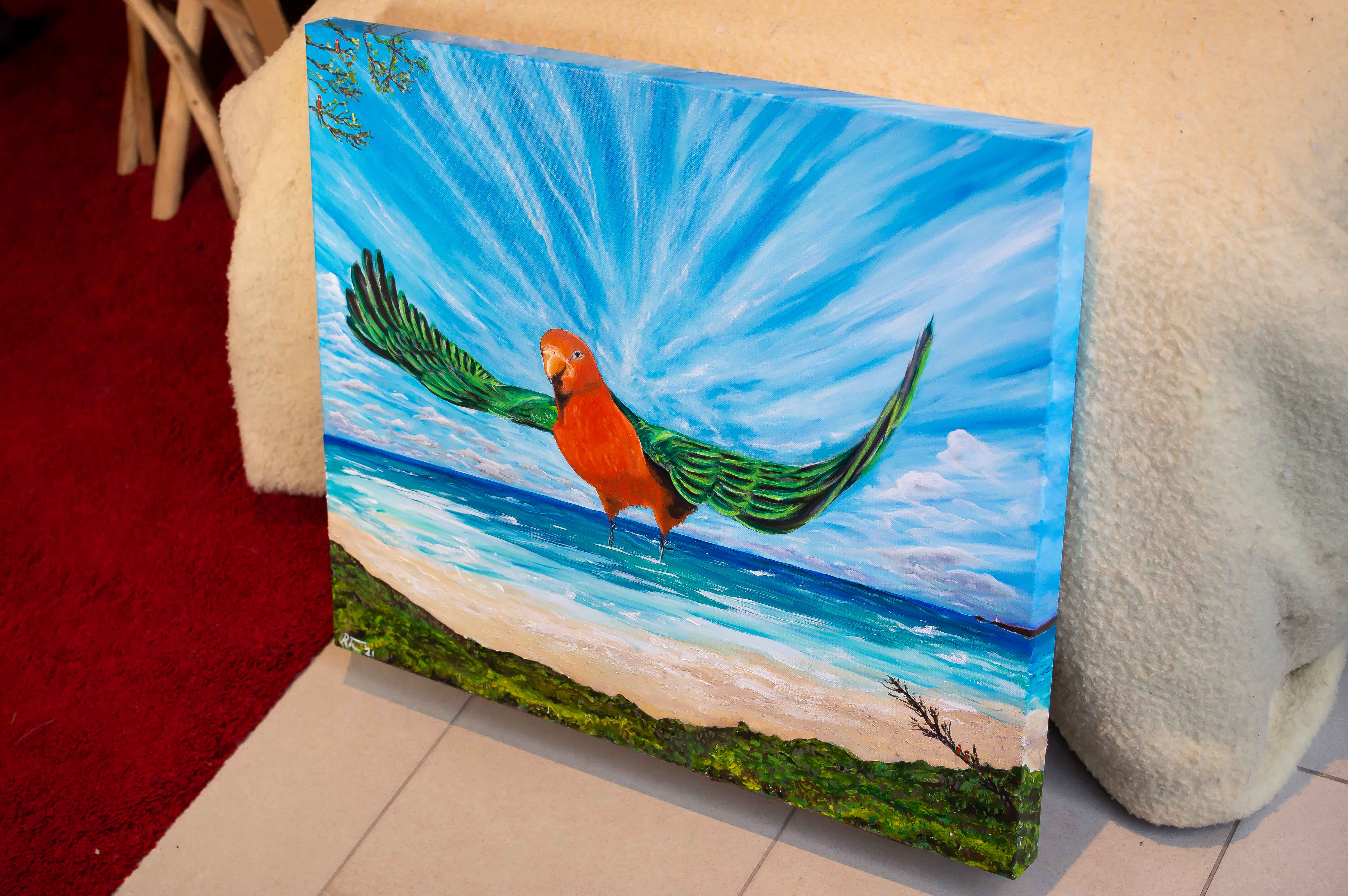 Acylic painting of a red and green Australian King Parrot flying over a large beach landscape. Dramatic clouds and white sandy beaches emphasise the scene and the figure of the parrot in the centre of the painting.